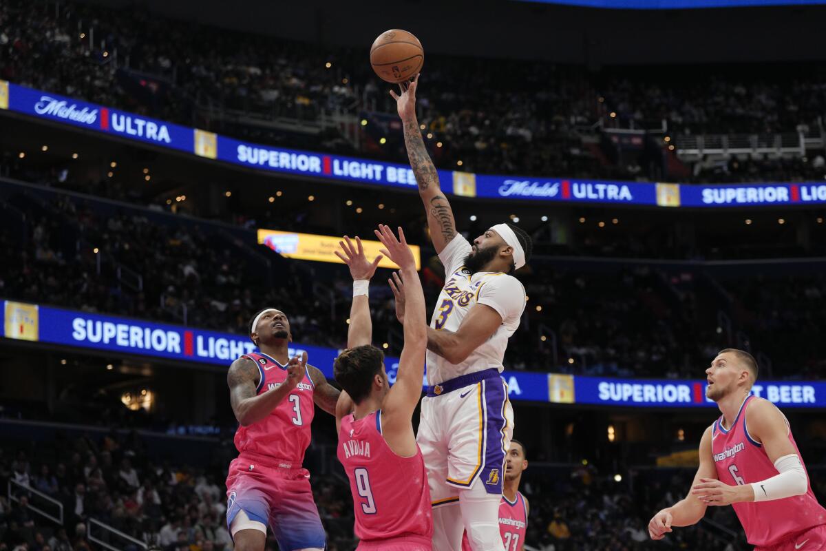 Lakers forward Anthony Davis elevates above Wizards defenders for a close-range shot.
