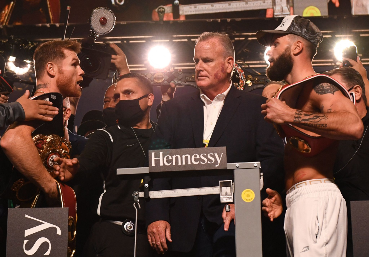 Boxers Canelo ?lvarez and Caleb Plant shout at each other while standing on stage during their weigh-in