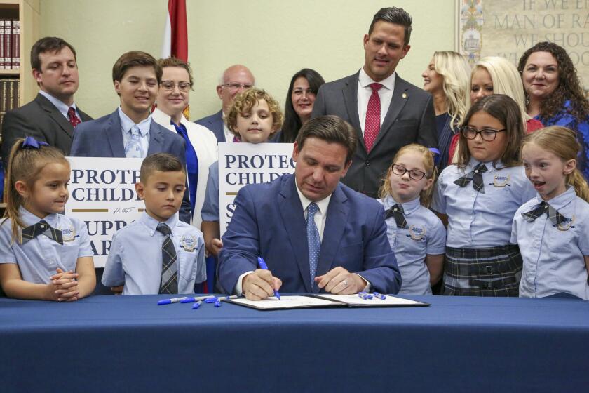 FILE - Florida Gov. Ron DeSantis signs the Parental Rights in Education bill at Classical Preparatory school on March 28, 2022, in Shady Hills, Fla. The Florida Board of Education on Wednesday, April 19, 2023, approved a ban on classroom instruction about sexual orientation and gender identity in all grades, expanding the law critics call “Don't Say Gay” at the request of Gov. DeSantis as he gears up for an expected presidential run. (Douglas R. Clifford/Tampa Bay Times via AP, File)