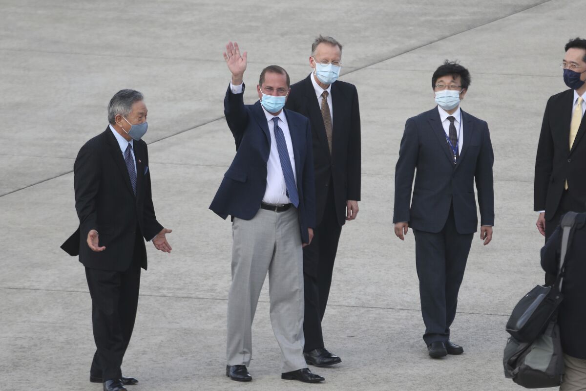 U.S. Health and Human Services Secretary Alex Azar, second left, waves to media as he arrives at Taipei Songshan Airport in Taipei, Taiwan, Sunday, Aug. 9, 2020. Azar arrived in Taiwan on Sunday in the highest-level visit by an American Cabinet official since the break in formal diplomatic relations between Washington and Taipei in 1979. (AP Photo/Chiang Ying-ying)