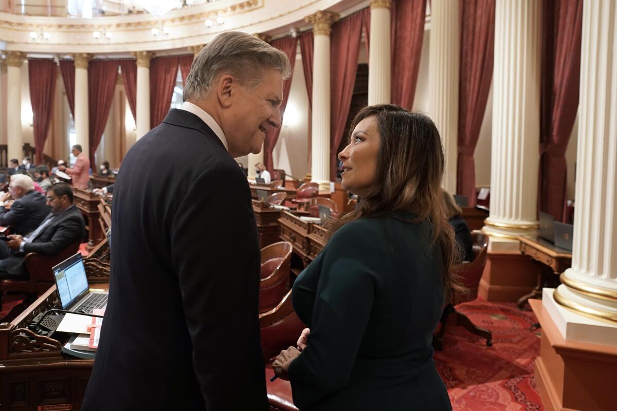 State Sens. Robert Hertzberg, left, and Rosilicie Ochoa Bogh talk on the chamber floor in Sacramento.