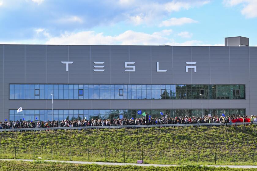 ARCHIVO - Manifestantes caminan frente a la fábrica de Tesla en Gruenheide, Alemania, el 11 de mayo de 2024, tras finalizar su protesta. (Patrick Pleul/dpa vía AP, Archivo)