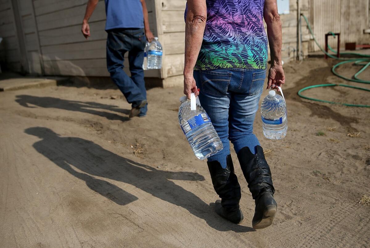 Drinking water is delivered in April to a resident in Porterville, Calif., which has no running water.