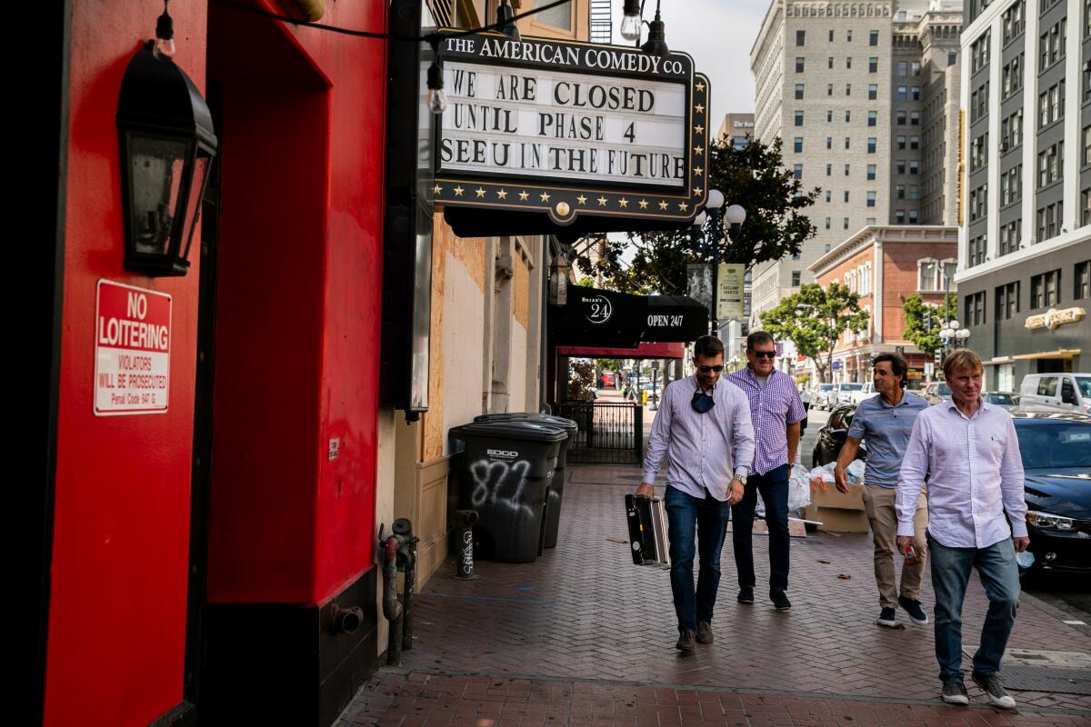 People pass by the American Comedy Club Co. in downtown San Diego on Thursday.