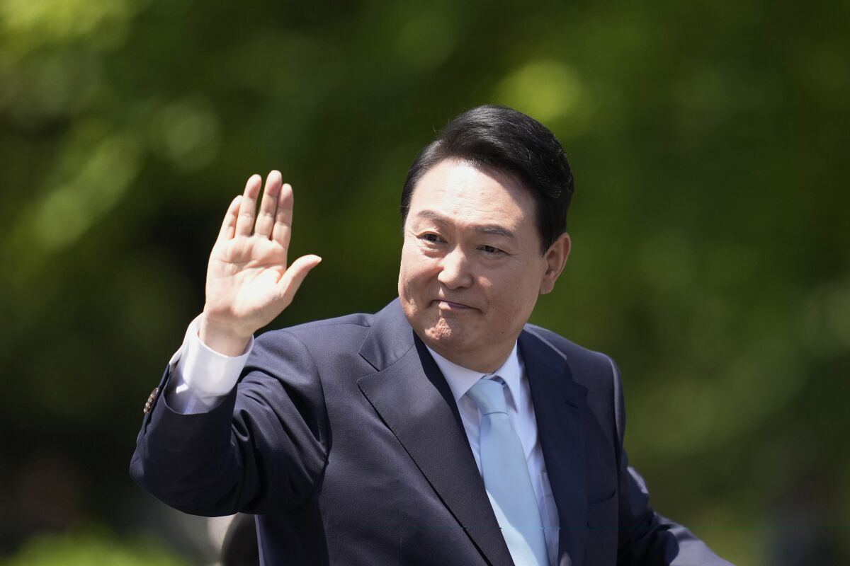 South Korea's new President Yoon Suk Yeol waves from a car after the Presidential Inauguration outside the National Assembly in Seoul, South Korea, Tuesday, May 10, 2022. (AP Photo/Lee Jin-man)