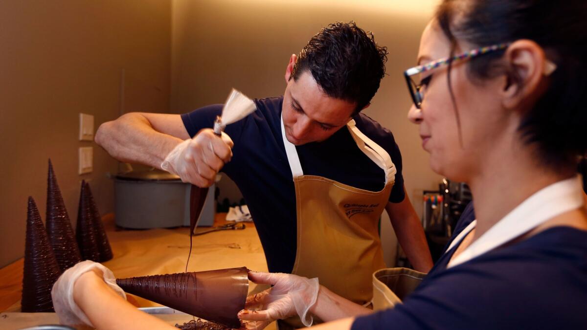 Pastry Chef Christophe Rull, left, and cake decorator Liz Marek make chocolate Christmas trees for a large edible holiday display at the Park Hyatt Aviara in Carlsbad.