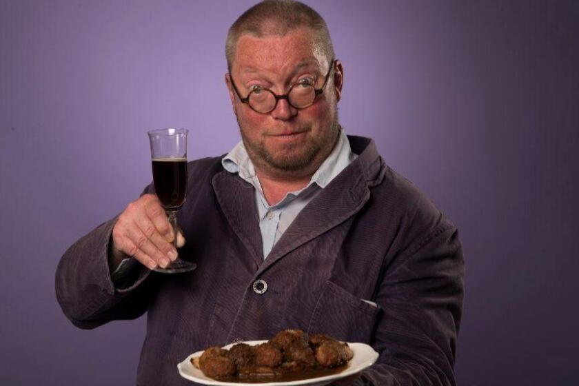 British chef Fergus Henderson holds a plate of deviled kidneys and a glass of Black Velvet.
