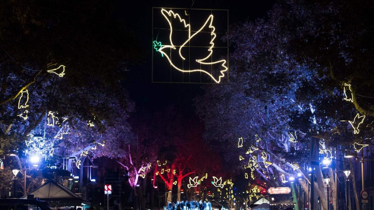 An illuminated peace dove hangs over Las Ramblas in Barcelona, Spain.