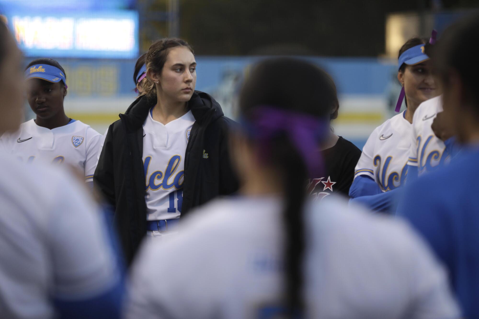 Bruins bullpen catcher Sara Rusconi Vicinanza, in black coat, hits the field with the team before a game against Utah.