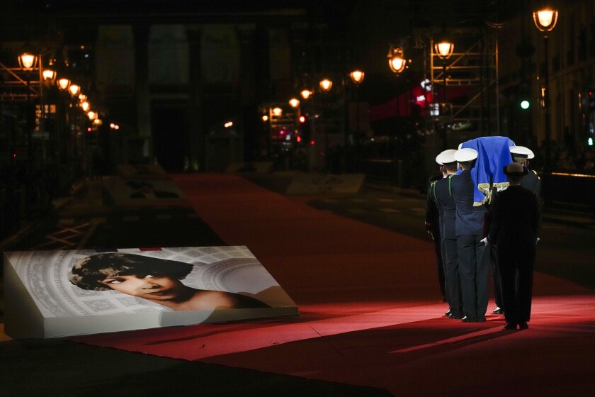 Pictures of Josephine Baker adorn the red carpet as the coffin with soils from the U.S., France and Monaco is carried towards the Pantheon monument in Paris, France, Tuesday, Nov. 30, 2021, where Baker is to symbolically be inducted, becoming the first Black woman to receive France's highest honor. Her body will stay in Monaco at the request of her family. (AP Photo/Christophe Ena)