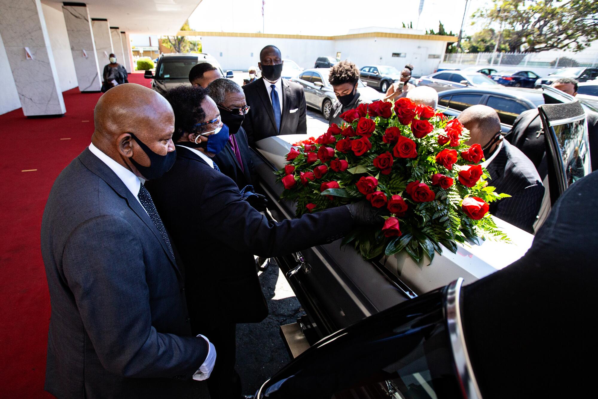 Family members load the casket carrying Charles Jackson Jr., who died from COVID-19, April 15 at the Angelus Funeral Home in Los Angeles.