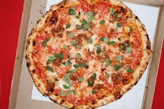 Pork-and-beef bolognese pizza topped with fresh basil in a pizza box at Bub and Grandma's Pizza in Highland Park.