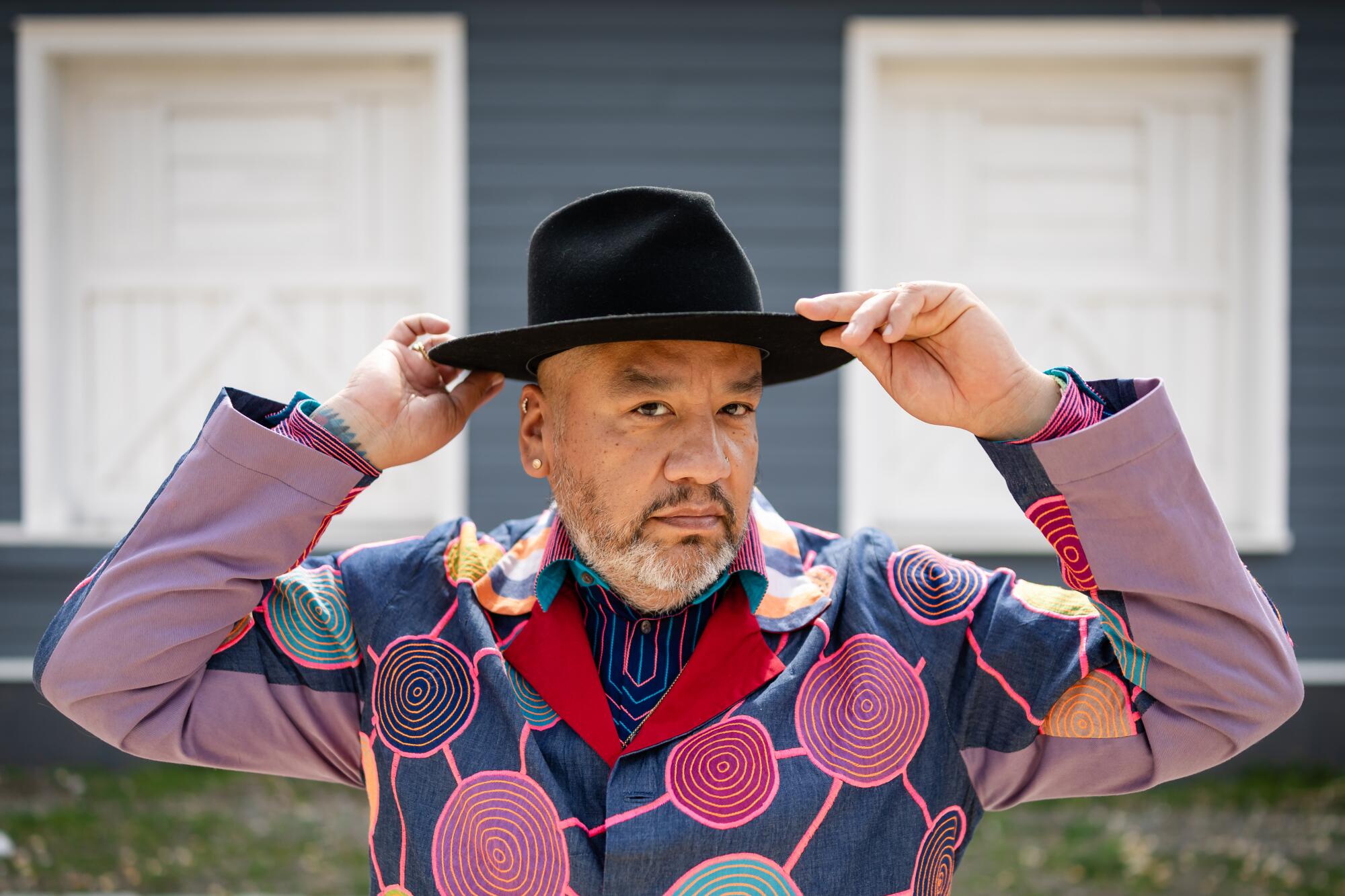 Artist Jeffrey Gibson adjusts his hat outside his studio near Hudson, N.Y.