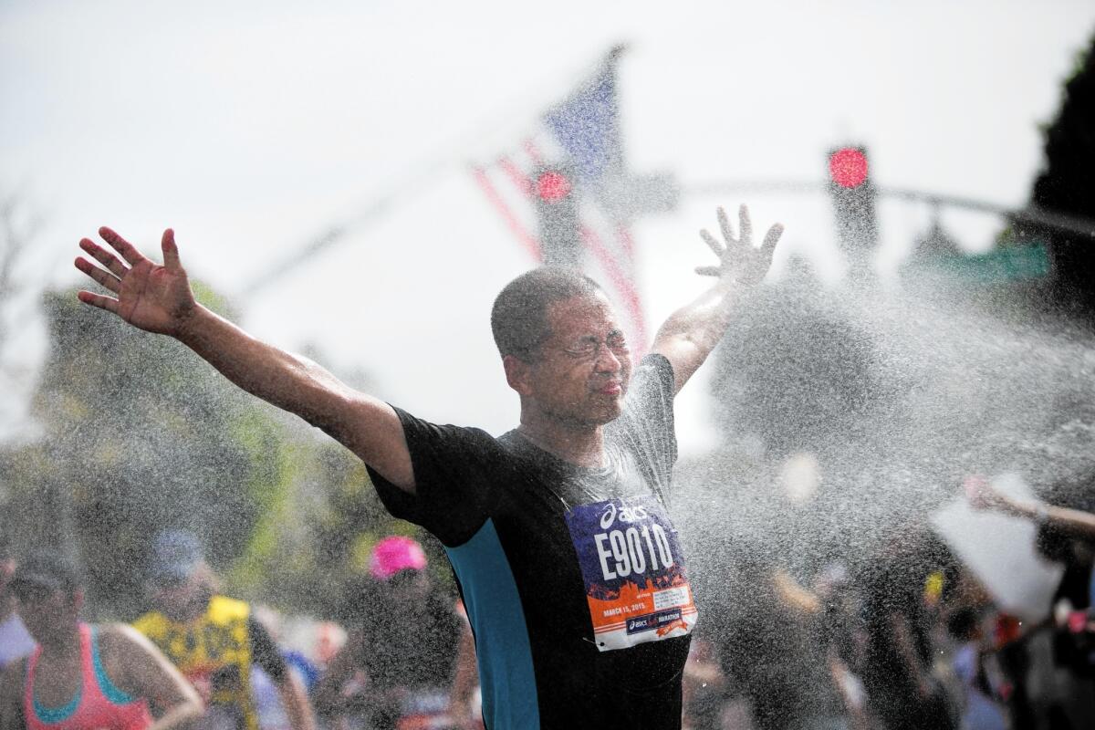 A Los Angeles Marathon runner revels in a cold spray of water at a station near mile-marker 16 in Beverly Hills.