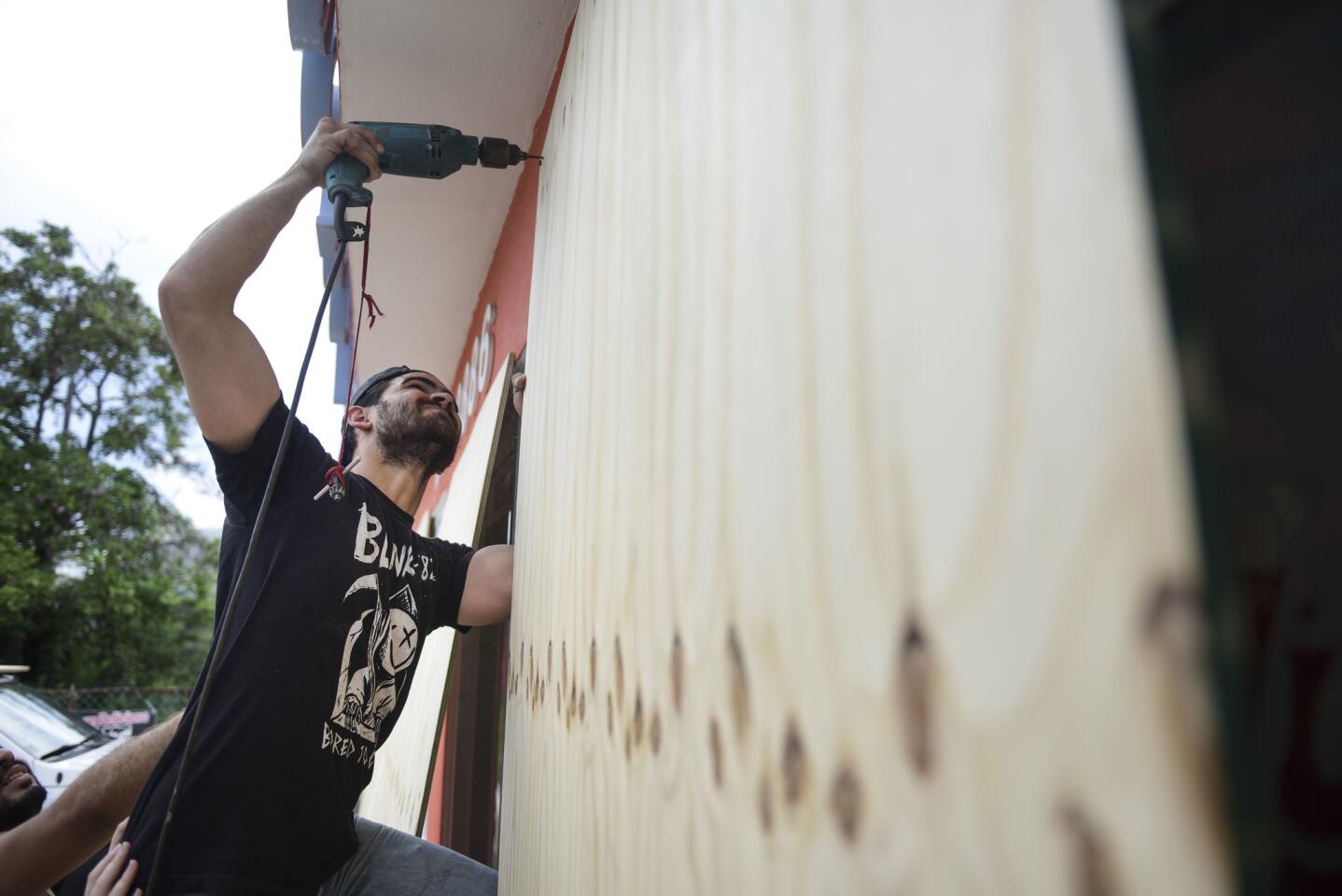 Cyber School Supply employee Christopher Rodriguez installs wood panels on windows in preparation for Hurricane Irma, in Toa Baja, Puerto Rico, Tuesday, Sept. 5, 2017