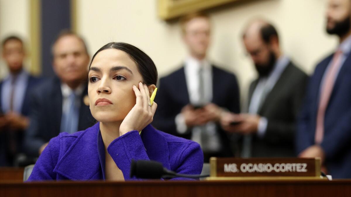 Rep. Alexandria Ocasio-Cortez (D-N.Y.) listens during a House Financial Services Committee hearing with leaders of major banks on April 10.