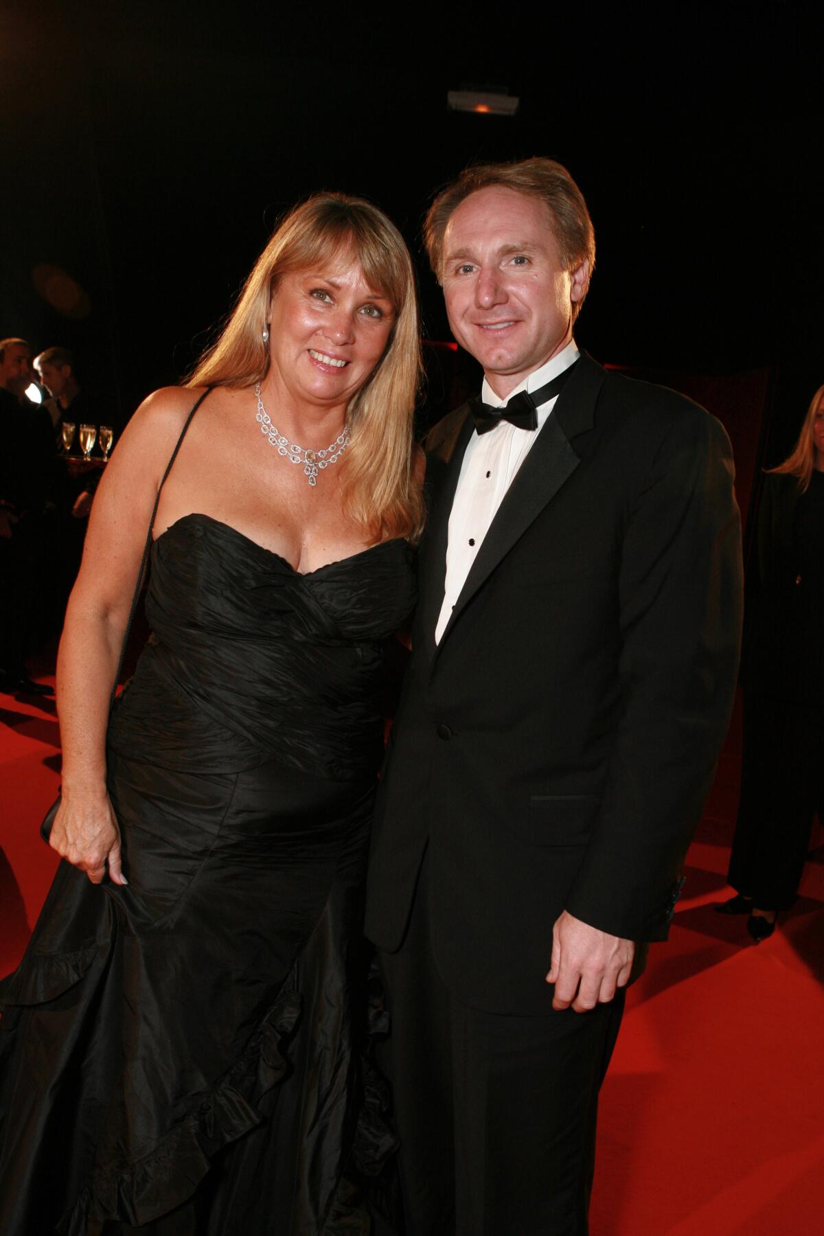 A woman in a black gown, right, and a man in a tuxedo