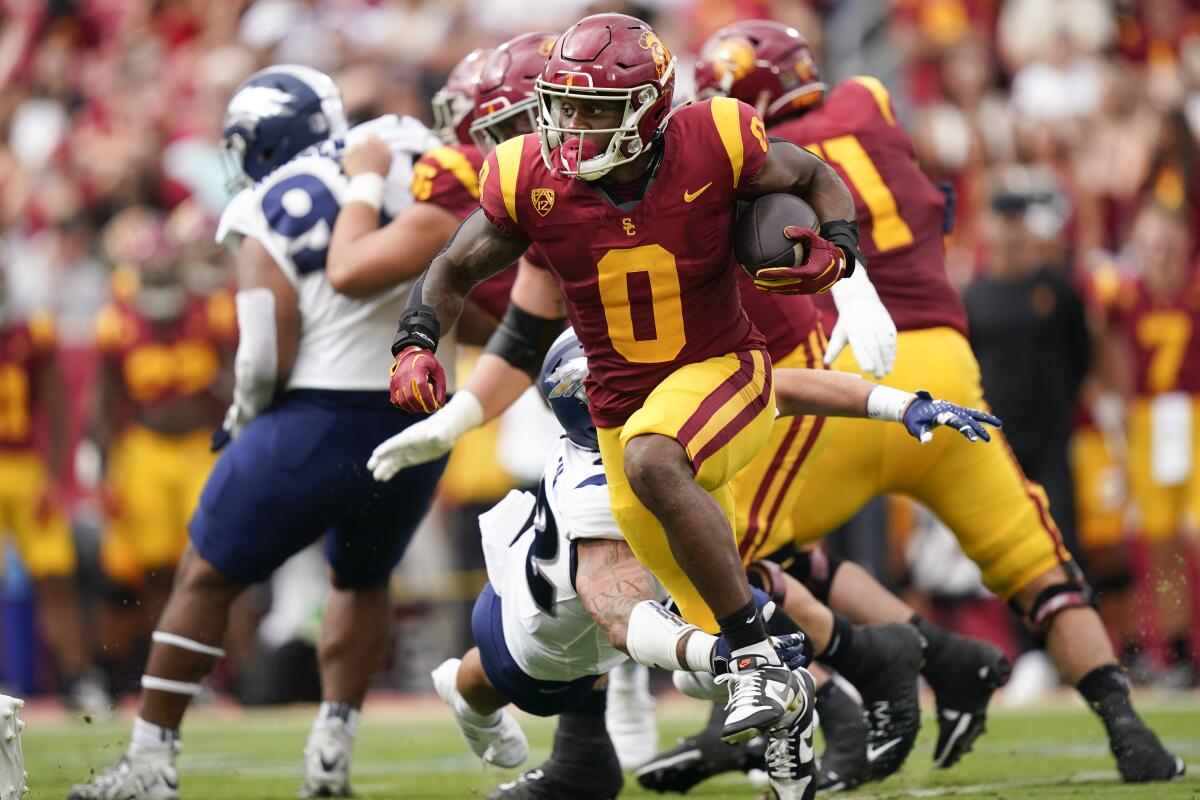 USC running back MarShawn Lloyd carries the ball while running past Nevada's defense.