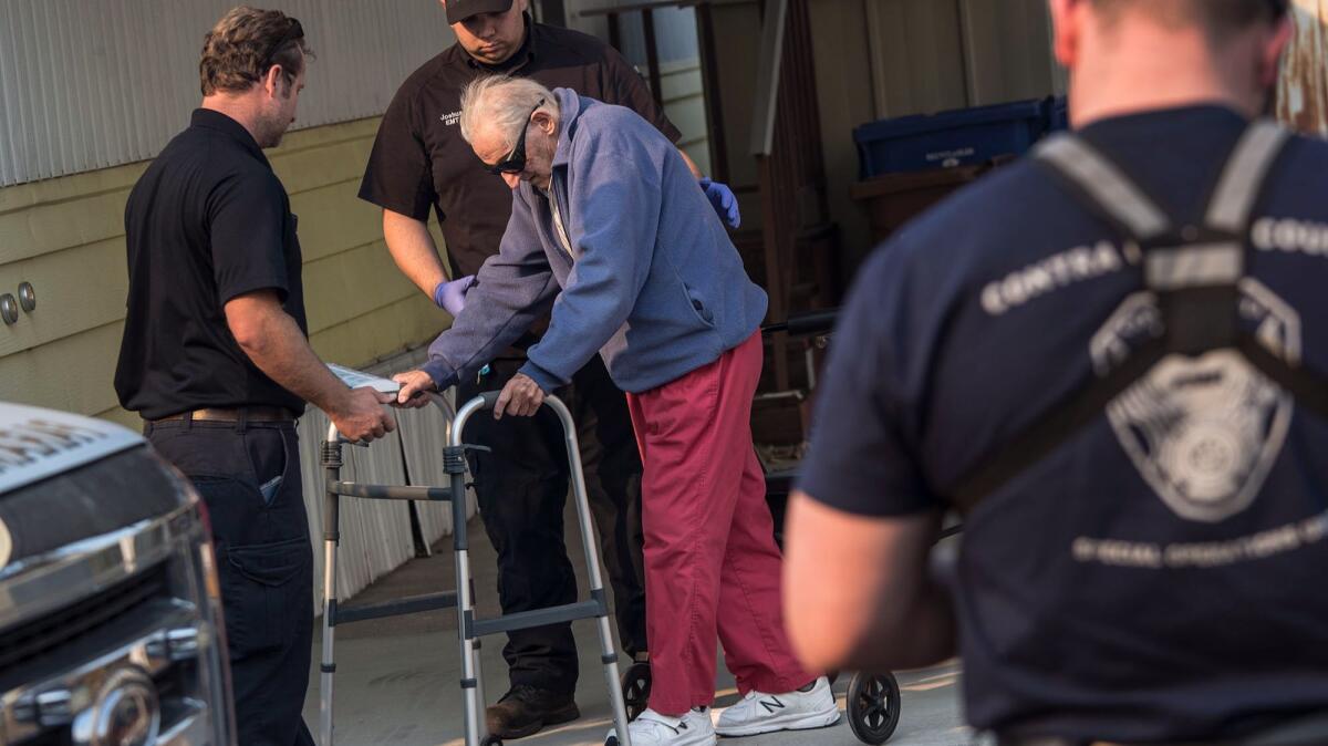 Contra Costa County paramedics help Bill Parras, 96, evacuate his home Wednesday in Calistoga, Calif.