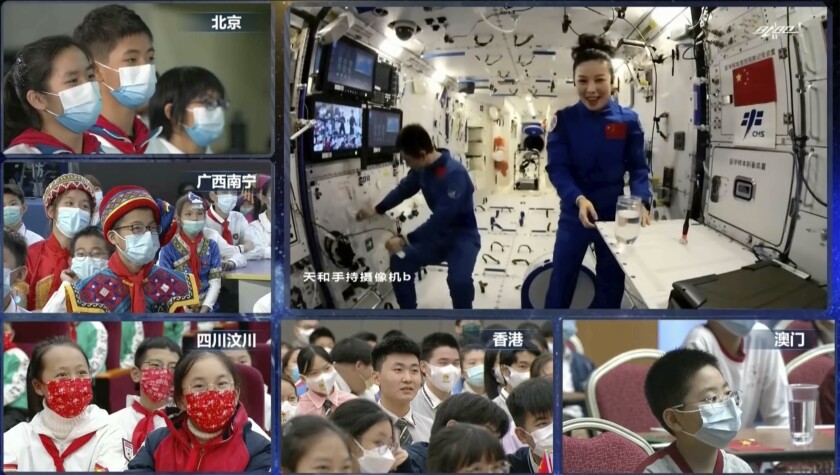 En esta imagen tomada de un video transmitido por la CCTV china, la astronauta Wang Yaping, derecha, habla con niños desde la estación espacial china en órbita alrededor de la Tierra, jueves 9 de diciembre de 2021. Astronautas chinos brindaron una clase de ciencia a estudiantes desde la estación espacial. (CCTV via AP)