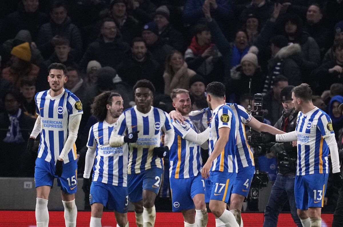 Brighton's Adam Webster celebrates with teammates after scoring his side's opening goal during the English Premier League soccer match between Brighton and Chelsea at the Falmer stadium in Brighton, England, Tuesday, Jan. 18, 2022. (AP Photo/Matt Dunham)