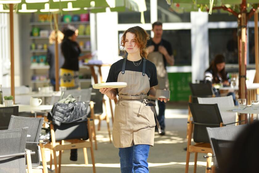 San Diego CA - February 8: Server Kate Liverman delivers a dish at The Kitchen, a restaurant in the outdoor courtyard of The Museum of Contemporary Art San Diego in La Jolla, which opens this week, shown here on Wednesday, February 8, 2023. (K.C. Alfred / The San Diego Union-Tribune)