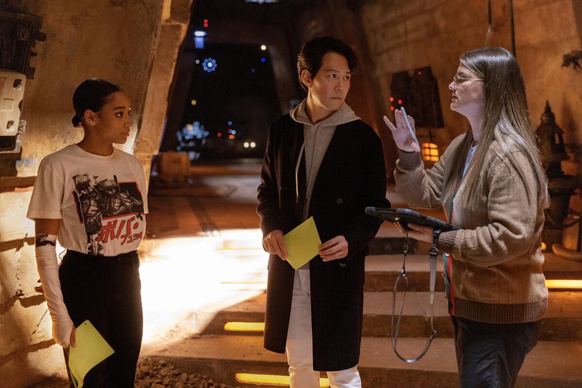 Left to right, Amandla Stenberg, Lee Jung-jae and Director Leslye Headland on the set of Lucasfilm's THE ACOLYTE, on Disney+.