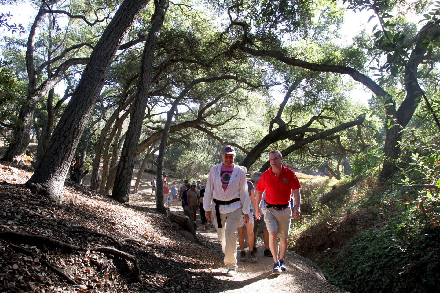 La Ca–ada Flintridge Trails Council president Caroline Craven, left, and mayor Jonathan Curtis, right, lead a large group on a hike from the Hampstead Road Trail Head to Ultimate Destination Point to celebrate the 30th anniversary of the open space at Cherry Canyon, in La Ca–ada Flintridge on Saturday, October 22, 2016 . At the location, the group tossed seed bombs out into the hillsides.