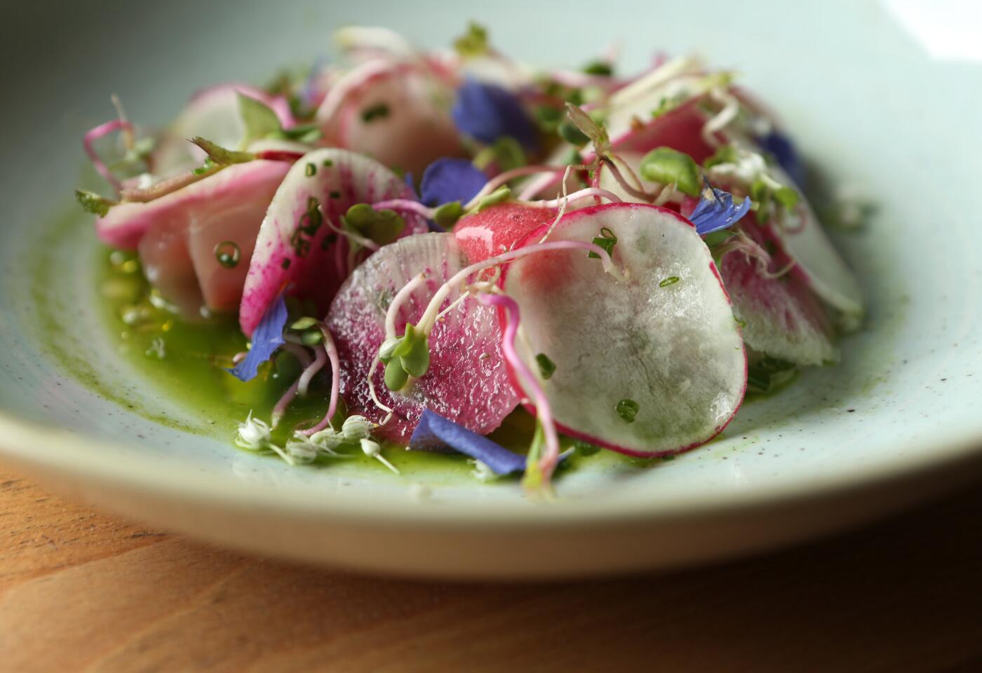 The yellowtail with radish, tomato and lemon with mustard greens, almond and preserved lemon at Kali Restaurant in Los Angeles.