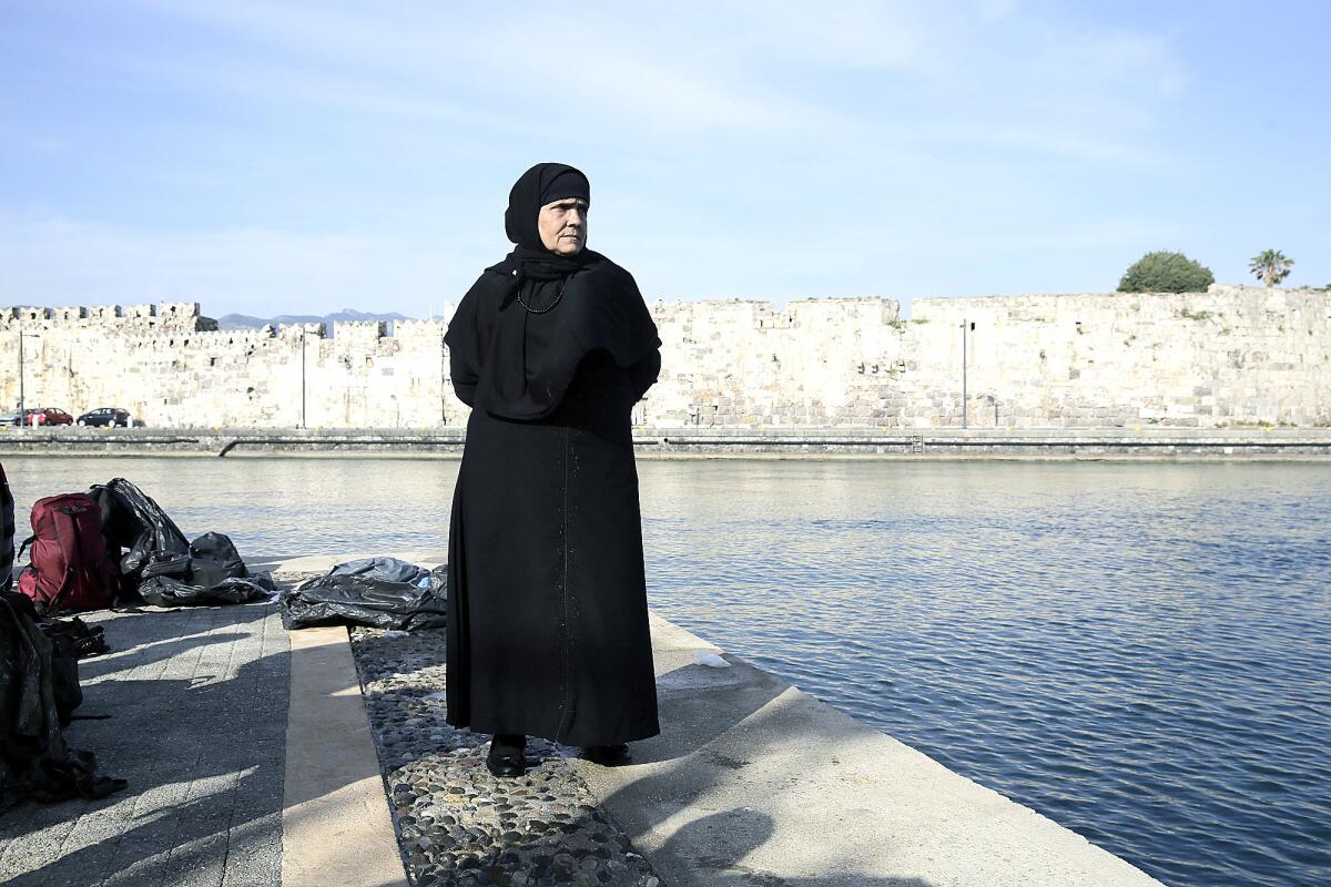 Una mujer migrante natural de Siria espera en el puerto de la isla de Kos, en Grecia, el 2 de junio de 2015, tras ser rescatada junto a otros por la guardia costera griega mientras intentaban cruzar de Turquía a Grecia en un barco.