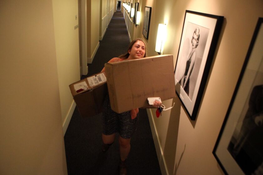 "Witches of East End" production assistant Amy Thurlow carries boxes from the mailroom at Sunset Bronson Studios in Hollywood.
