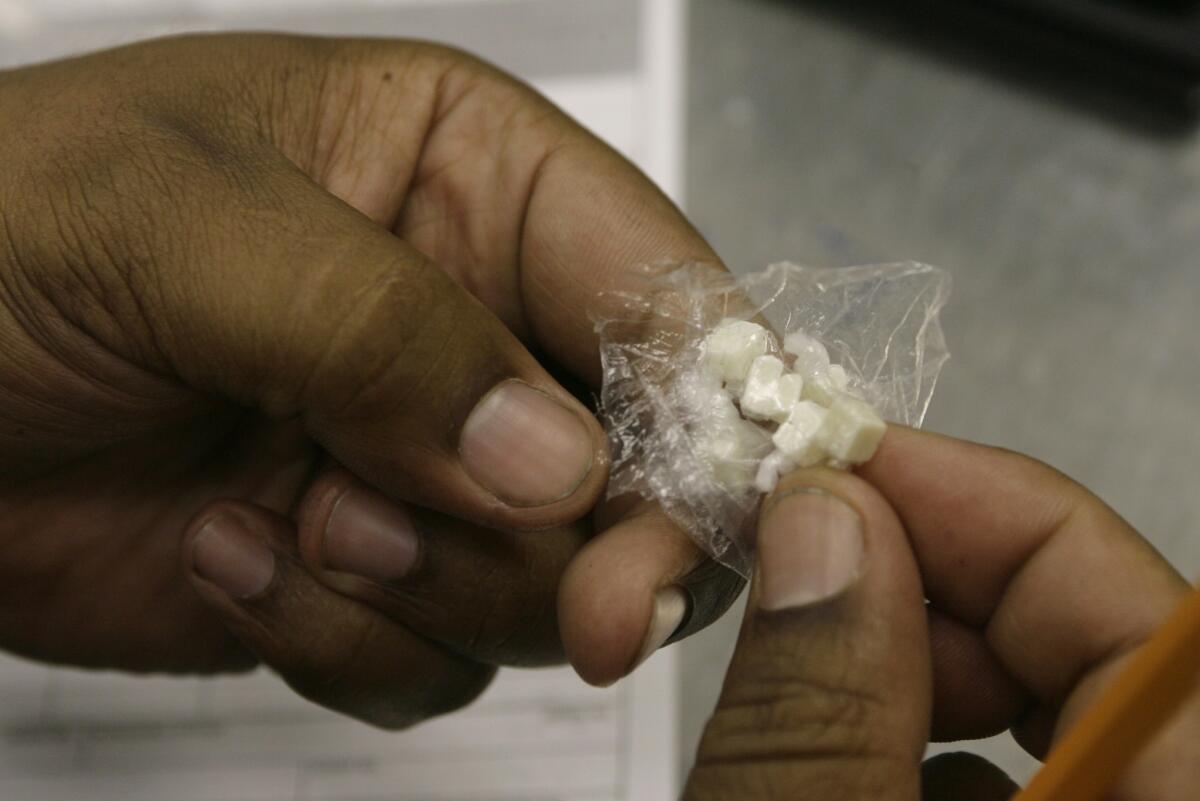 An LAPD officer looks at crack cocaine seized during an arrest in downtown Los Angeles.