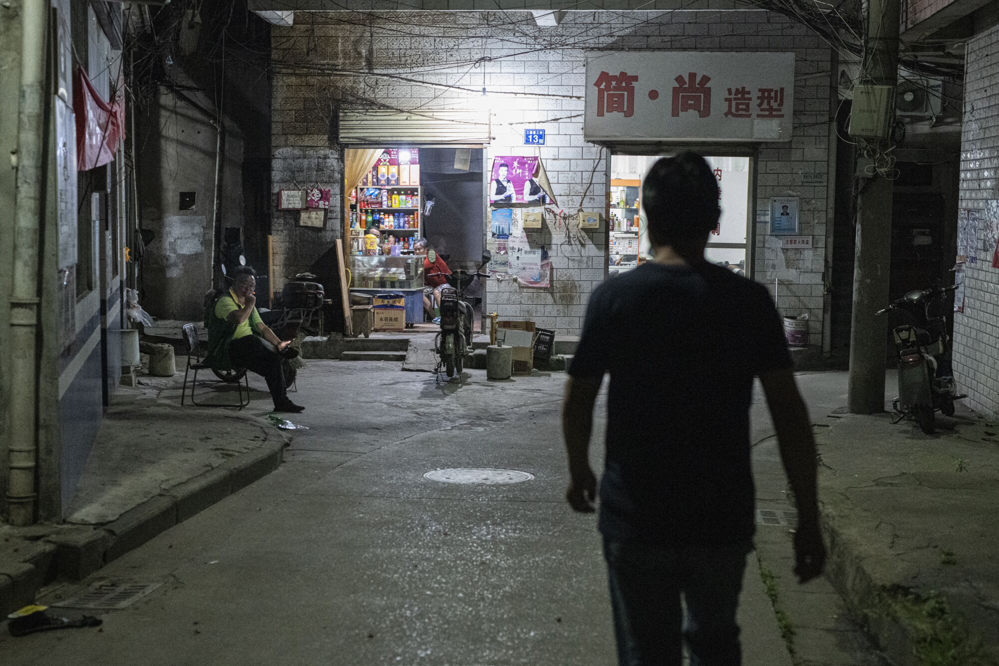 Wang Guoqing, a migrant worker in Wuhan, walks toward his rented home
