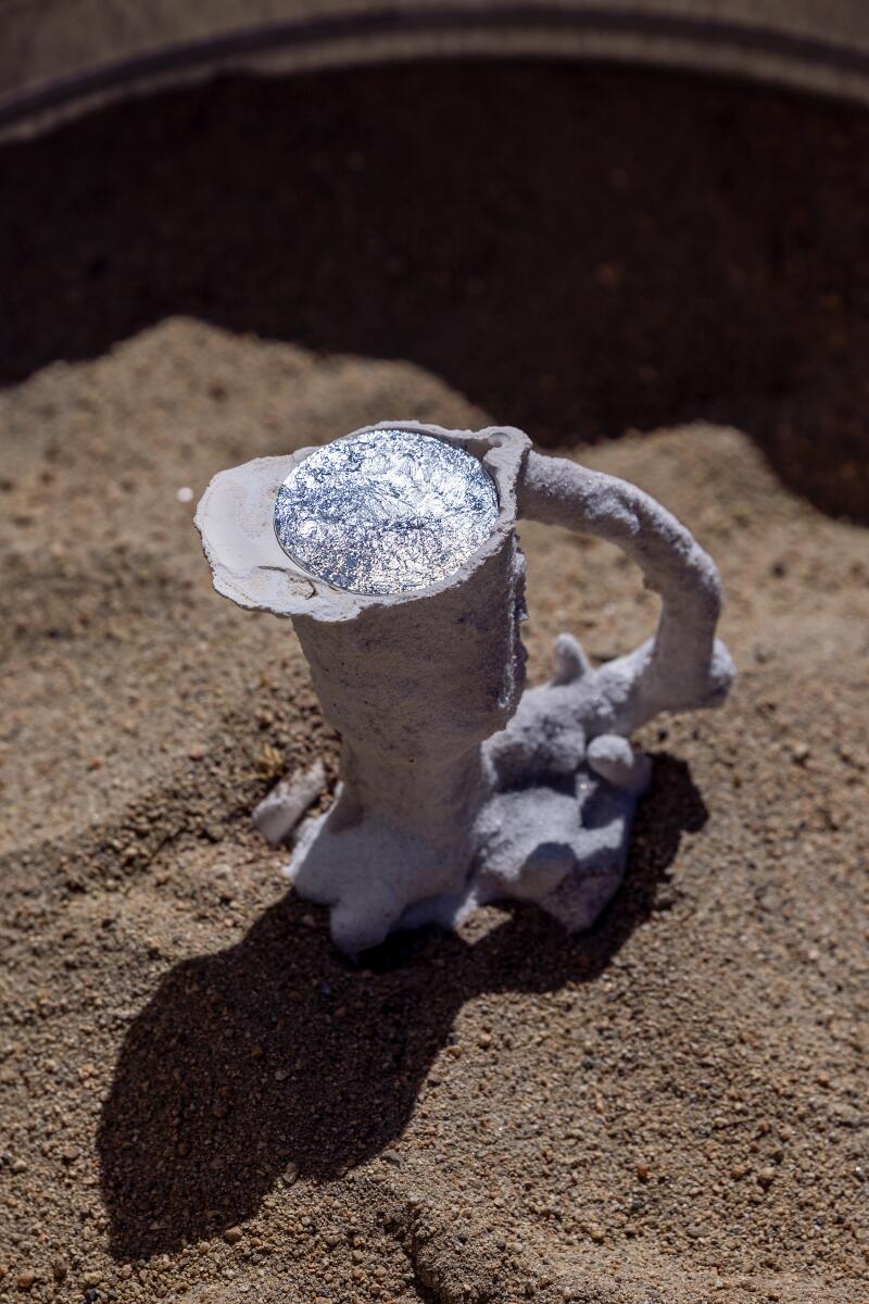 Molten aluminum in a mold with a handle sitting on the ground.
