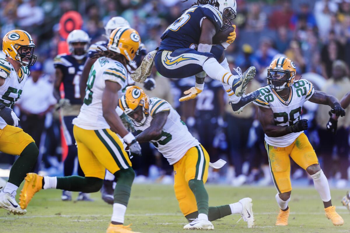 Chargers running back Melvin Gordon leaps over Packers defensive back Chandon Sullivan.