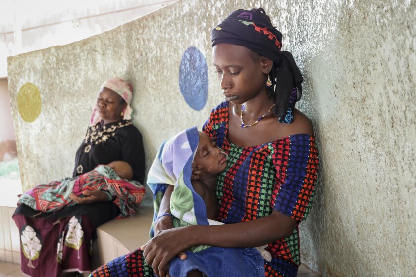 Fatima Li, 20, foreground, holds her two-year-old son, Hama Sow, as he is treated with a feeding tube for malnourishment, as Hadiara Ouedraogo, left, sits with her granddaughter, Fatimata Ouedrago, 2, who has edema due to severe malnourishment, at Yalgado Ouedraogo University in Ouagadougou, Burkina Faso on Monday, June 22, 2020. In Burkina Faso one in five young children is chronically malnourished. Food prices have spiked, and 12 million of the country’s 20 million residents don’t get enough to eat. (AP Photo/Sam Mednick)