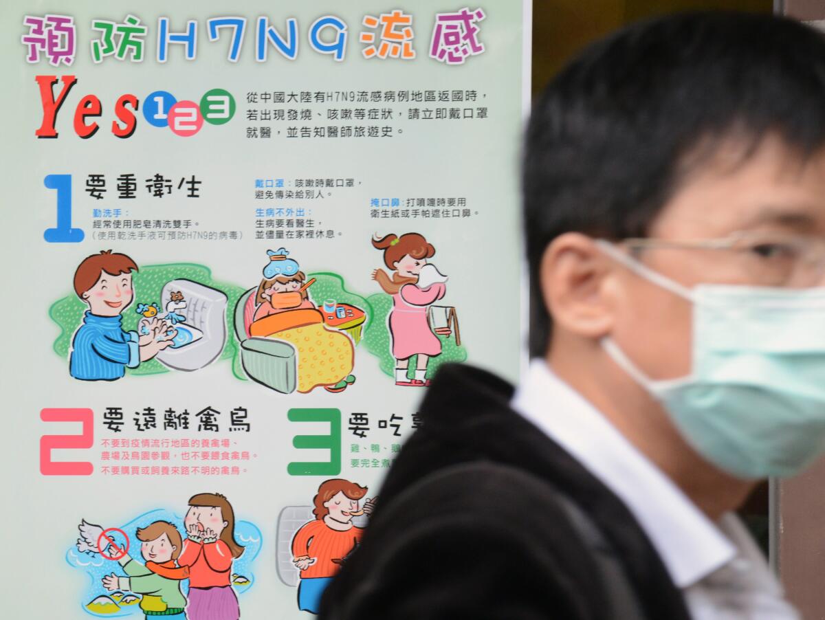 A man walks past an H7N9 poster outside the National Taiwan University Hospital in Taipei.
