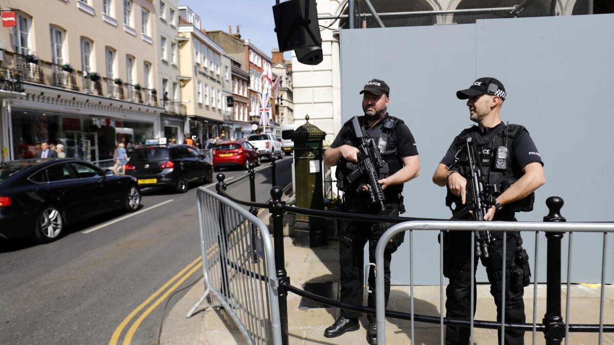 Armed British police officers patrol the streets of Windsor on May 18, the day before the royal wedding.