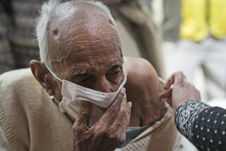 An elderly receives Covid-19 vaccination at a makeshift center in a government school in New Delhi, India, Friday, Jan. 28, 2022. Indian health officials said that the first signs of COVID-19 infections plateauing in some parts of the vast country were being seen, but cautioned that cases were still surging in some states. (AP Photo/Manish Swarup)