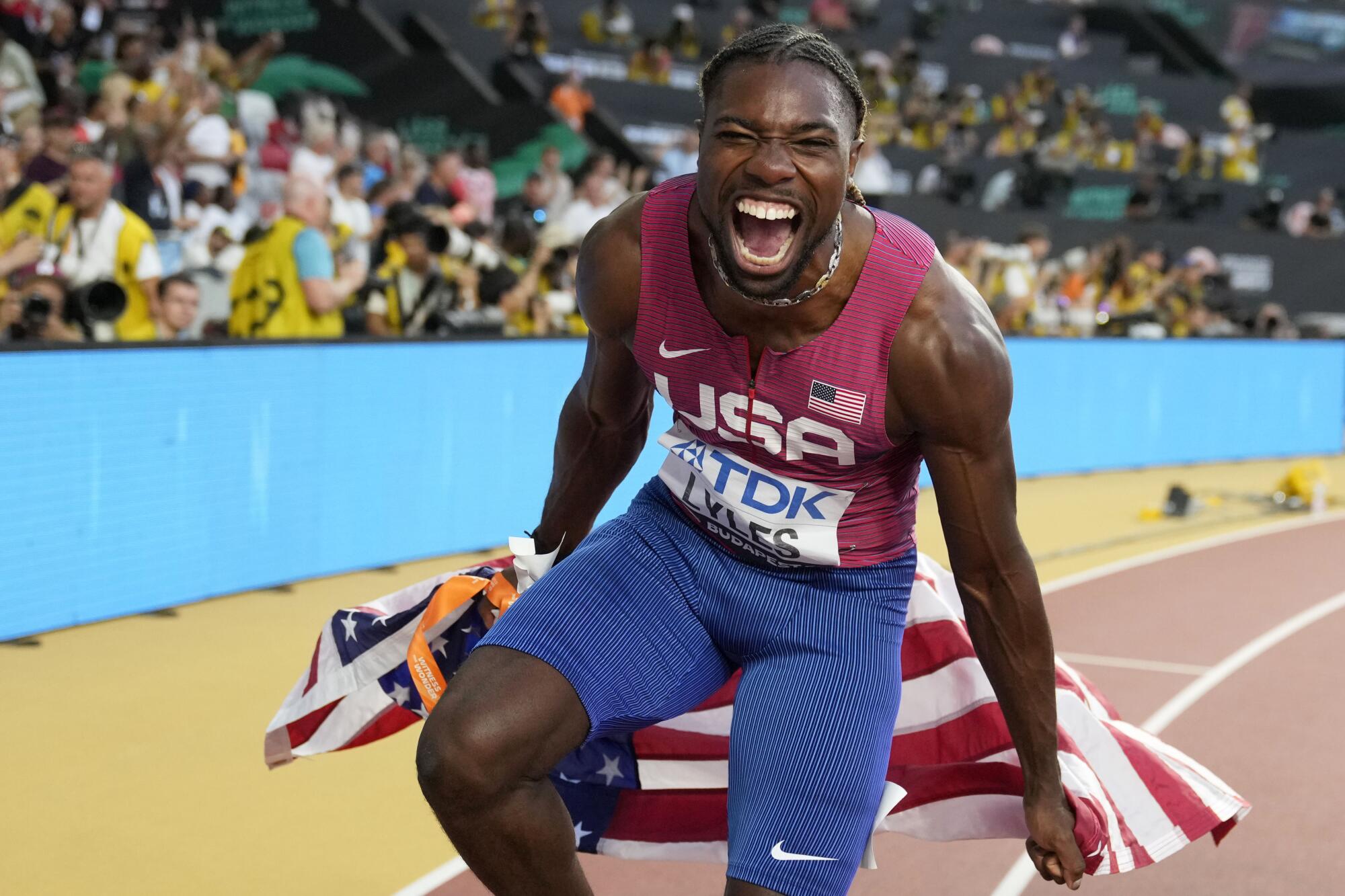 Noah Lyles celebrates after winning the gold medal in the men's 100 meters.