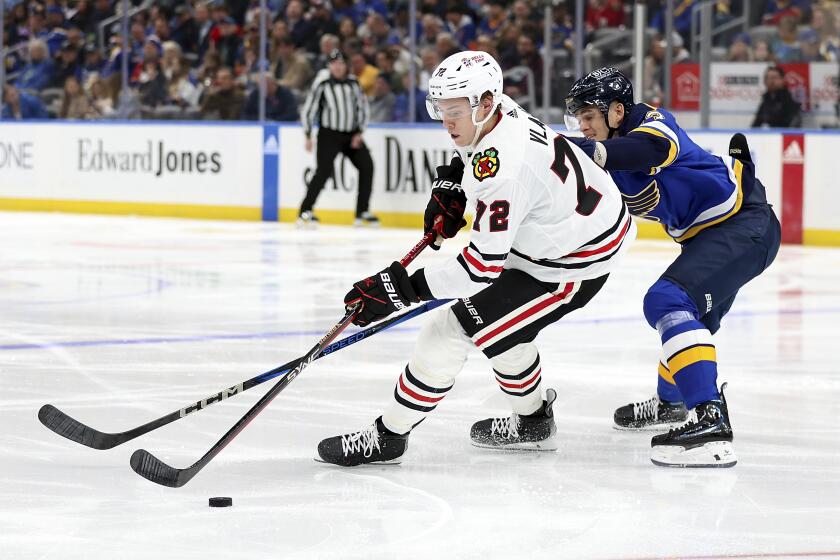 Chicago Blackhawks' Alex Vlasic (72) and St. Louis Blues' Alexey Toropchenko (13) vie for control of the puck during the second period of an NHL hockey game Wednesday, April 10, 2024, in St. Louis. (AP Photo/Scott Kane)