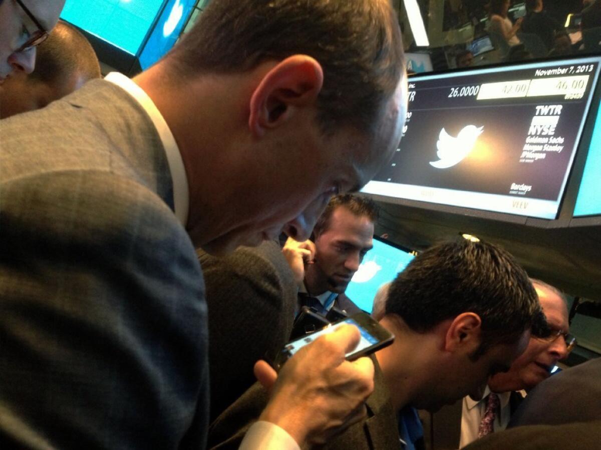 Twitter CEO Dick Costolo tweets as he waits for the company's stock to open on the New York Stock Exchange.