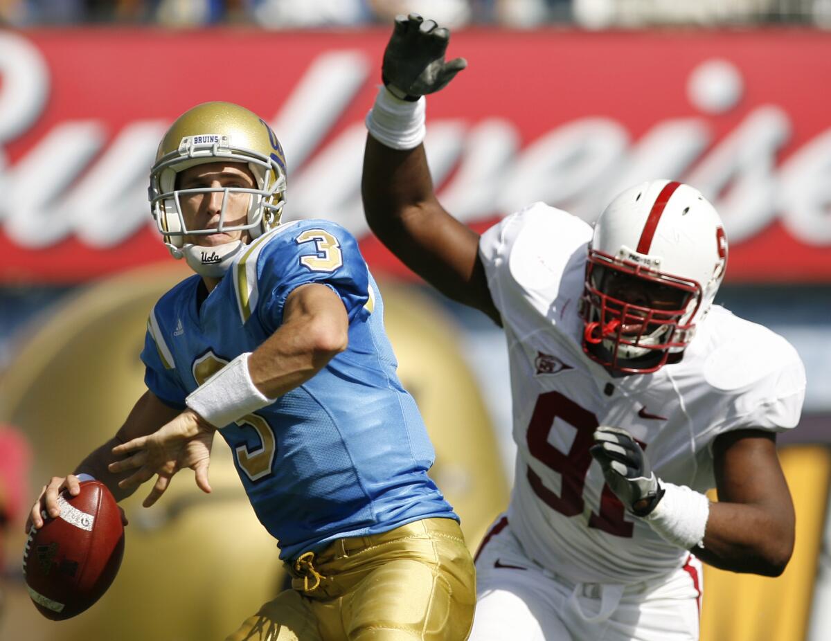 UCLA quarterback Kevin Craft looks to pass as Stanford defensive end Pannel Egboh puts on pressure.