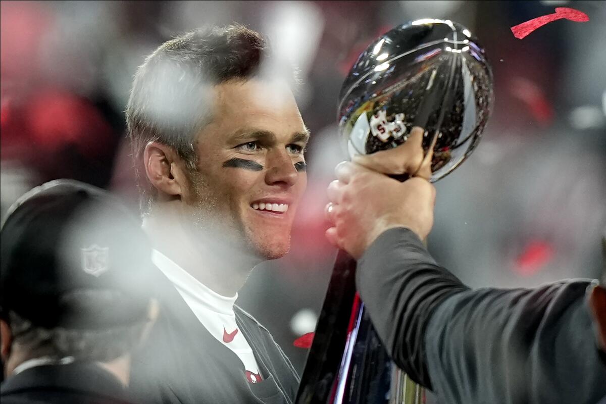 Tampa Bay quarterback Tom Brady looks at the Vince Lombardi trophy after winning his seventh Super Bowl on Sunday.
