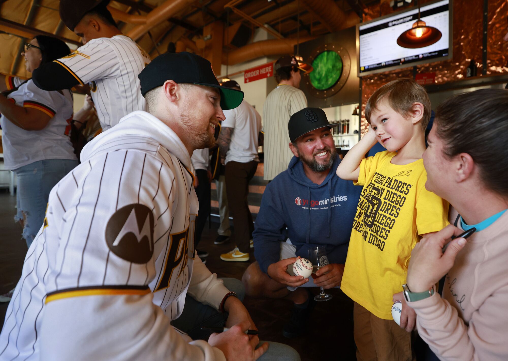 Padres' Jake Cronenworth greets Tyce Covert, 4, along with his parents Brad and Katie at Ballast Poi