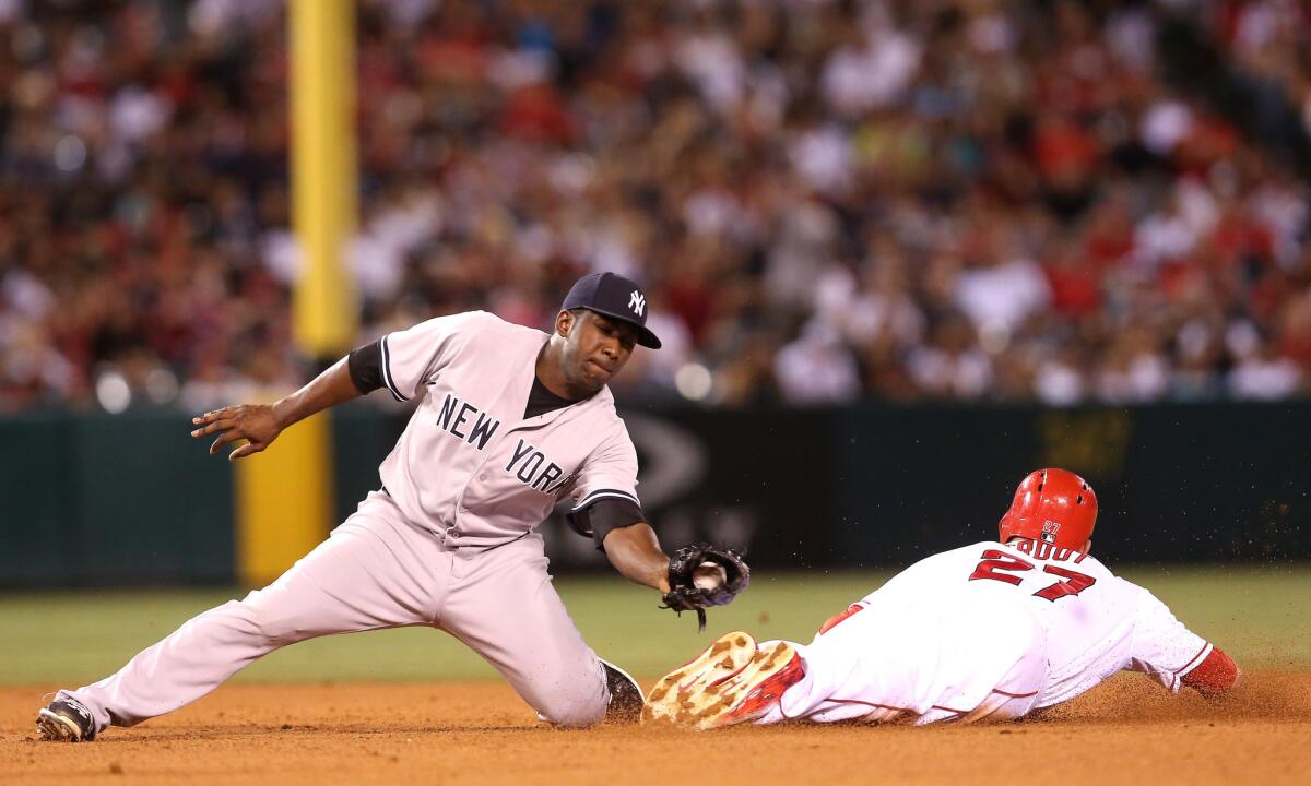 Angels outfielder Mike Trout slides in with a stolen base ahead of the tag by Yankees second baseman Jose Pirela.