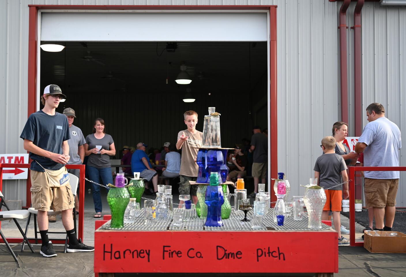 People try their luck at the dime pitch game during the carnival at the Harney Volunteer Fire Company on Tuesday, June 25.