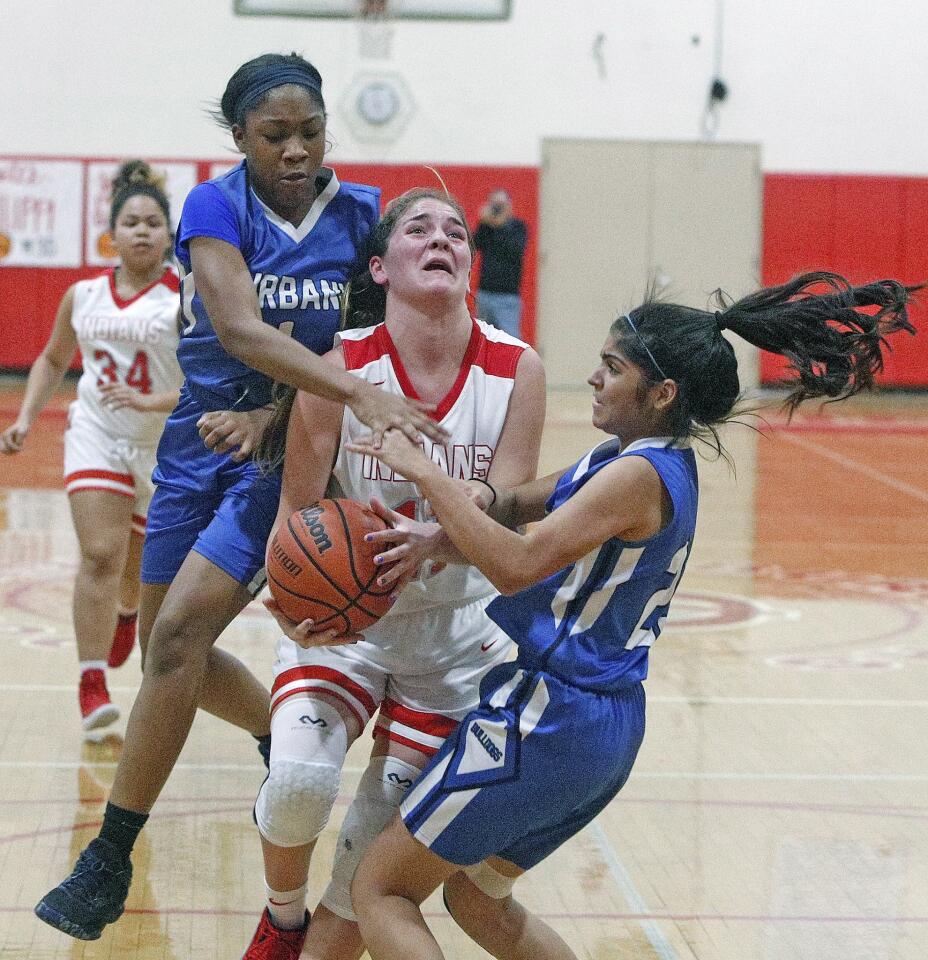 Burroughs' Kayla Wrobel drives to the basket in the closing seconds of the half and as time runs out, she is sandwiched by Burbank's Jayla Flowers and Erika Montoya in a rival Pacific League girls' basketball game at Burroughs High School in Burbank on Thursday, January 10, 2019.