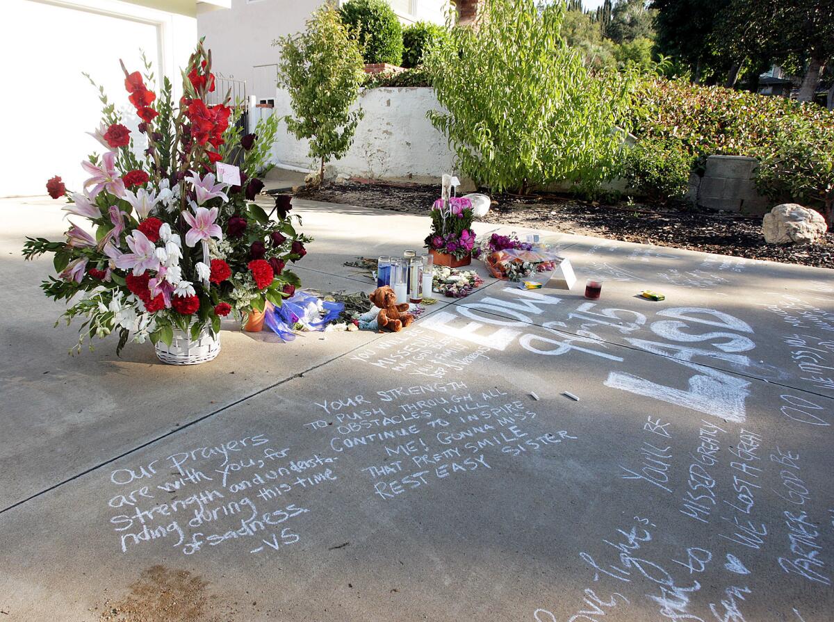 A memorial has been established on the driveway of Deputy Cecilia Hoschet and Firefighter/Paramedic James M. Taylor in La Cañada Flintridge on Wednesday, Sept. 9, 2015. On Sunday, Taylor killed Hoschet at the home before killing himself at a Los Angeles County Fire Department facility in Pacoima.