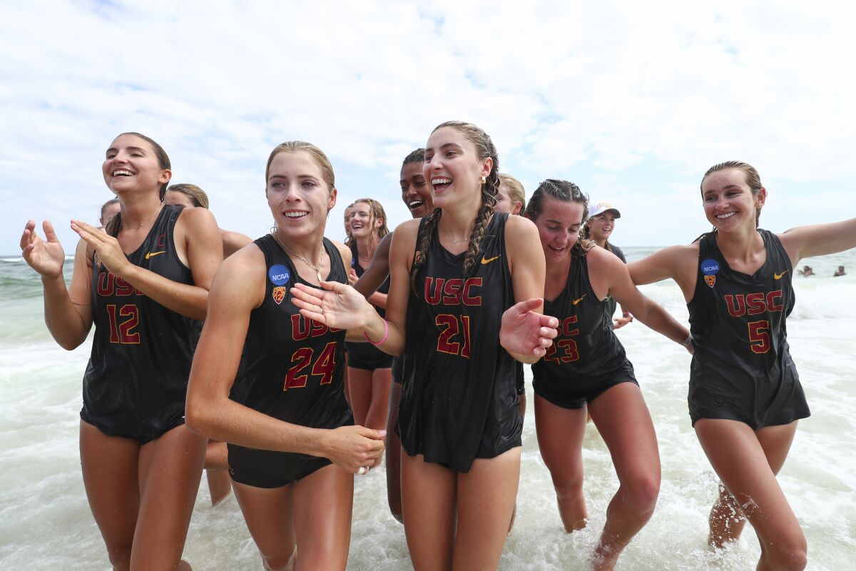 Haley Hallgren, far left, celebrates with USC teammates Audrey Nourse and Olivia Bakos.
